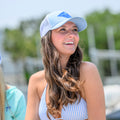Smiling woman on a boat wearing a wahoo blue Pole Dancer Diamond Patch trucker hat.
