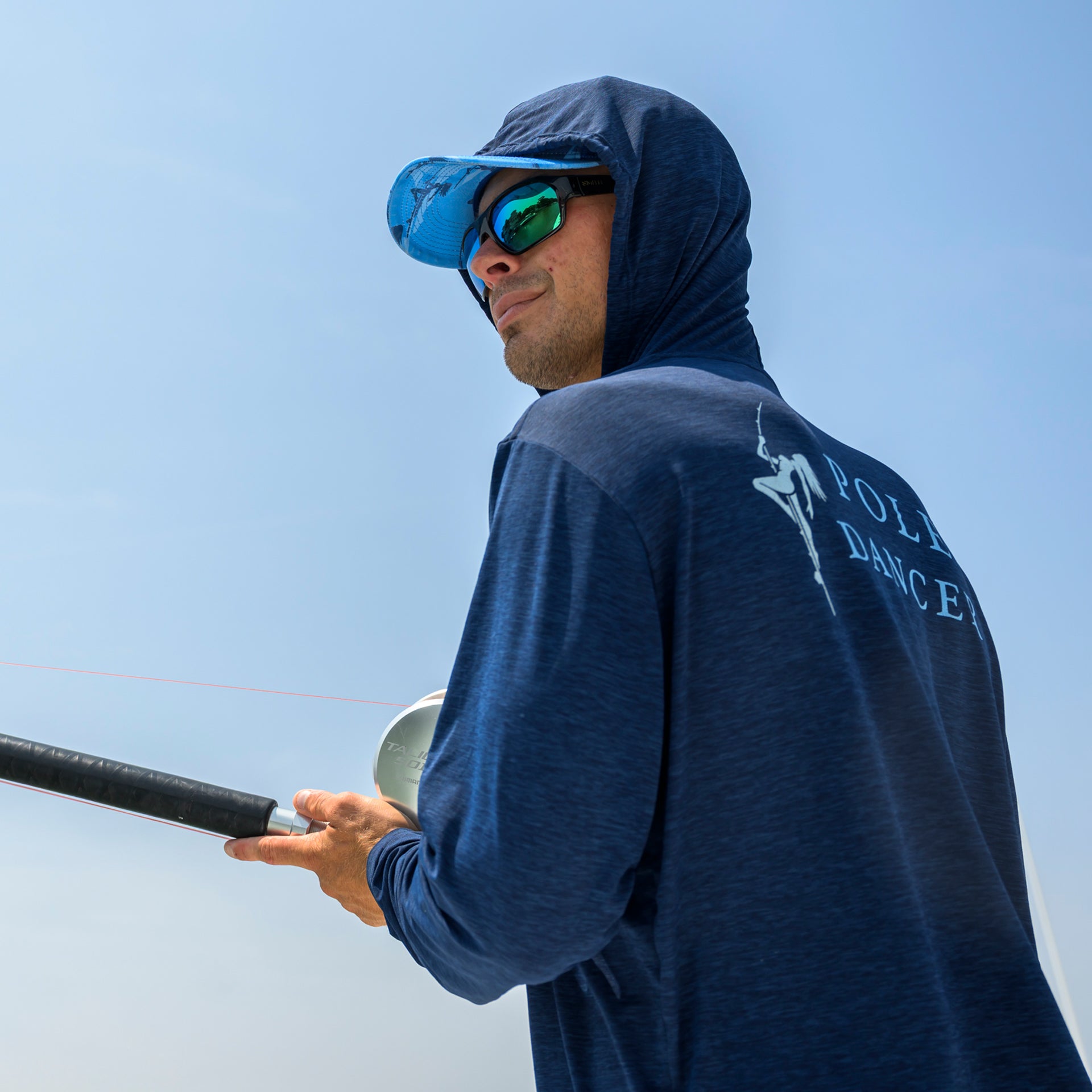 Man fishing in the Pole Dancer Heather/Navy Alpha Performance Hoodie.